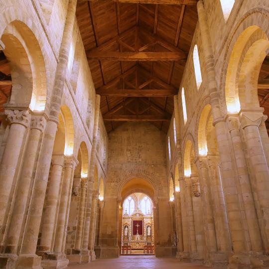 Nef romane de l'abbatiale de Graville, charpente en bois visible et piliers en pierre.